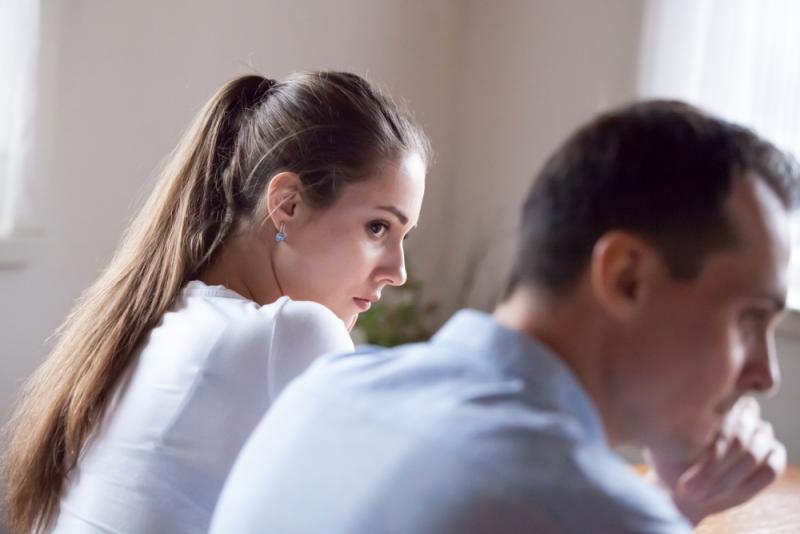 a women setting next to her husband and she seems sad