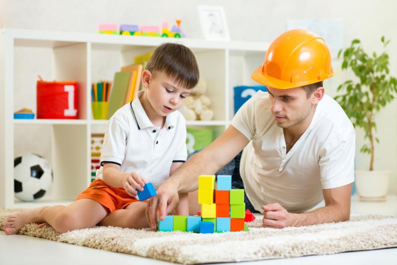 A father playing with bricks with his son 