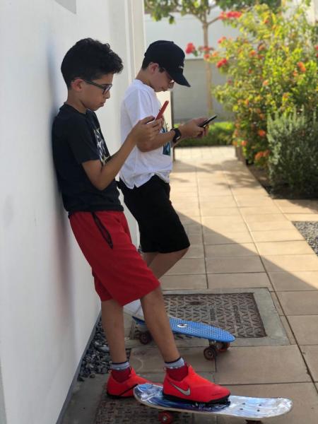 two kids playing with their phones