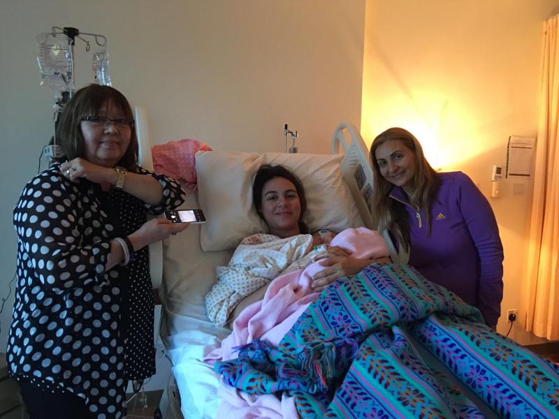 A Picture for a mom and her baby girl with the Doula in the hospital